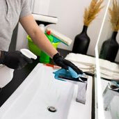 Mann med hansker vasker servant