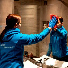 Kvinne rengjør speil på bad